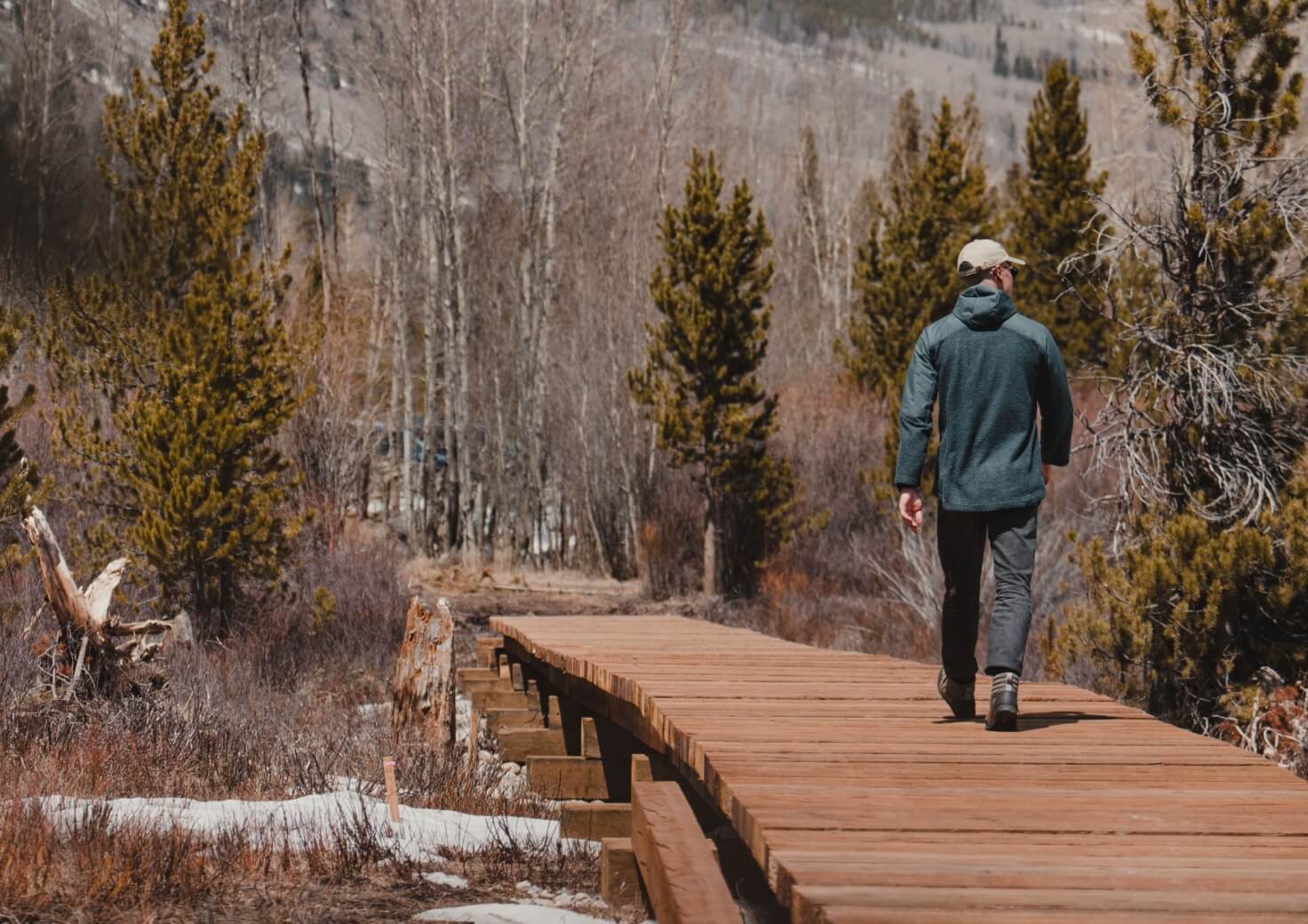 Forsake Men's featuring a man walking on a wood planked path.